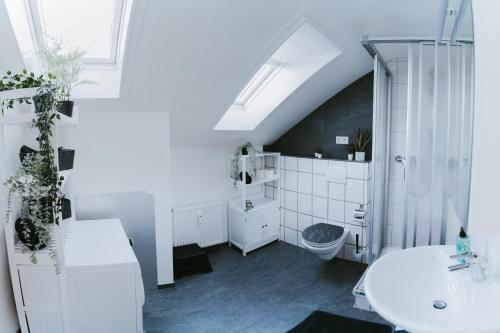 a white bathroom with a sink and a toilet at Ferienwohnung Seeblick Wadee in Radolfzell am Bodensee
