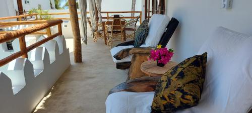 a room with couches and a table with a vase of flowers at Namayani apartment in Pwani Mchangani
