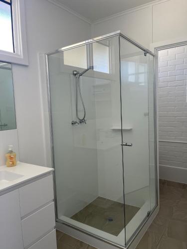 a shower with a glass door in a bathroom at Busselton Jetty Chalets in Busselton