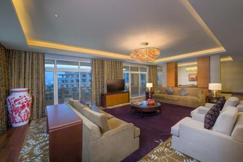 a large living room with couches and a television at Grand Hyatt Doha Hotel & Villas in Doha