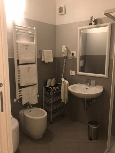 a bathroom with a sink and a toilet and a mirror at La Terrazza Vercelli Bed & Charme in Vercelli