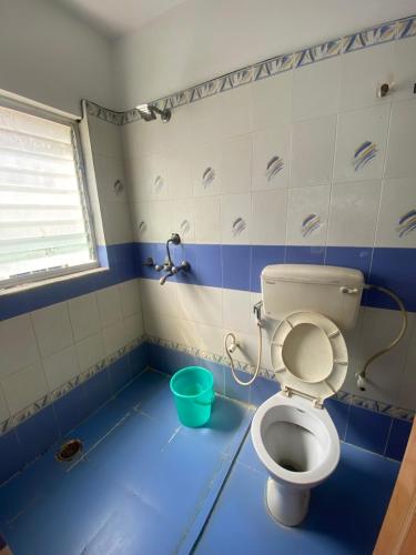 uma casa de banho com WC e piso azul em Ditto Room Jairam Golden Beach, New Digha em Digha