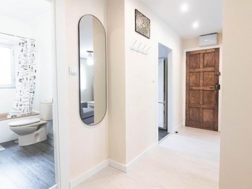 a bathroom with a toilet and a mirror at Apartamento chile playa in Gijón