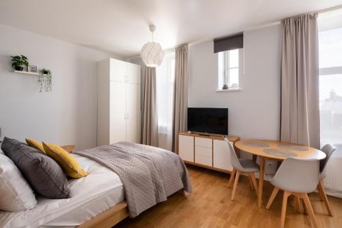 a bedroom with a bed and a table and a television at Residential Barona Apartments in Riga Centre in Rīga
