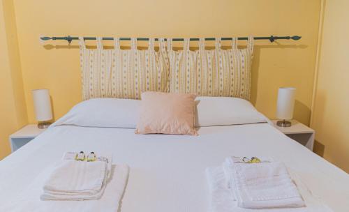 a bedroom with a white bed with towels on it at Agriturismo Montevecchio Isolani in Monte San Pietro