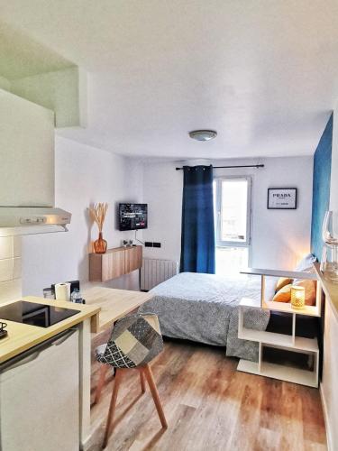 a small bedroom with a bed and a kitchen at La Studieuse - Hyper centre ville in Noisy-le-Grand