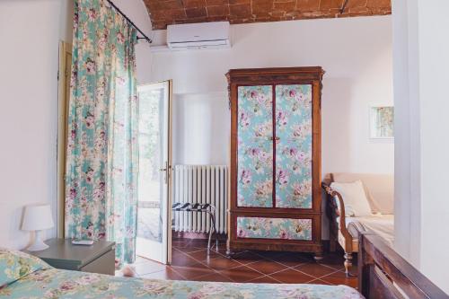 a bedroom with a bed and a window with curtains at Agriturismo Montevecchio Isolani in Monte San Pietro