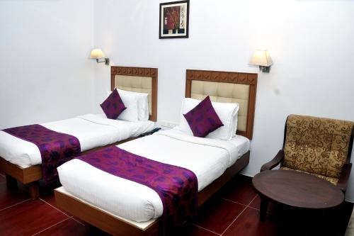Chakkarakkal的住宿－BROAD BEAN Chakkarakkal，酒店客房,配有两张床和椅子