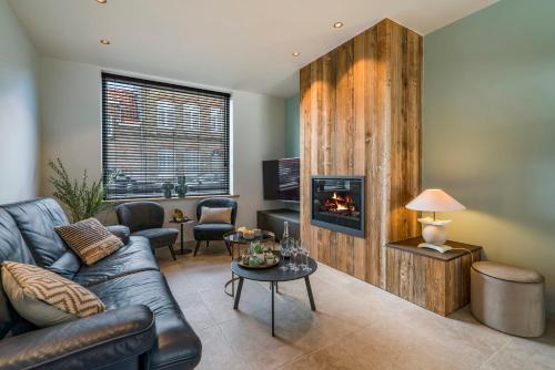 ein Wohnzimmer mit Couch und Kamin in der Unterkunft Maison Odett - fully renovated house for 10 people in Nieuwpoort