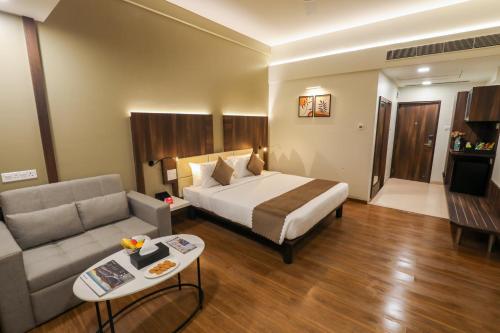 um quarto de hotel com uma cama e um sofá em Spree Hotel Aurangabad em Aurangabad