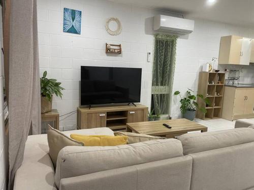a living room with a couch and a flat screen tv at Withanee in Picnic Bay