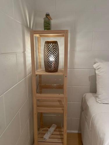 a book shelf with a vase on it next to a bed at Withanee in Picnic Bay