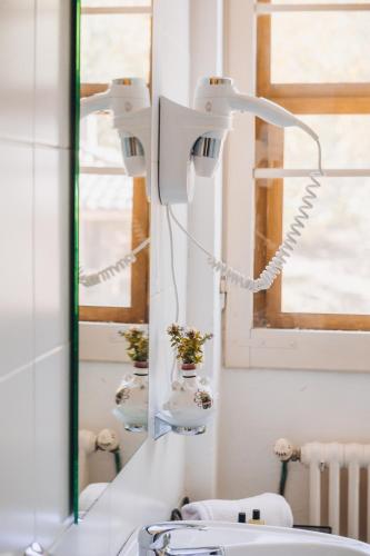 a bathroom with two lights and a sink and a mirror at Agriturismo Montevecchio Isolani in Monte San Pietro