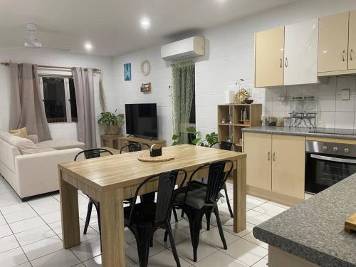 eine Küche und ein Wohnzimmer mit einem Holztisch und Stühlen in der Unterkunft Withanee in Picnic Bay