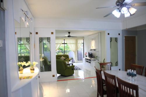 a living room with a table and a green chair at Isabella Villa George Town Penang in George Town