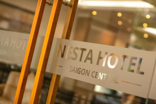 a sign for a nesta hotel on a window at Nesta Hotel Saigon in Ho Chi Minh City