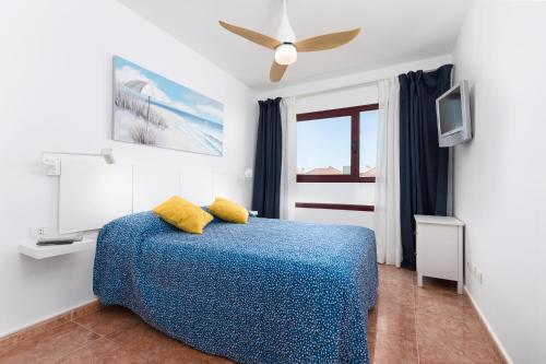 a bedroom with a bed and a ceiling fan at Home2Book Casa La Pepita 2 in Caleta De Fuste