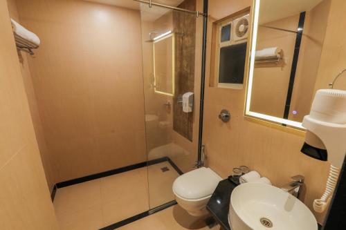 a bathroom with a shower and a toilet and a sink at Spree Hotel Aurangabad in Aurangabad