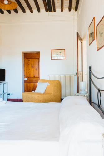 a bedroom with two beds and a tv at Agriturismo Montevecchio Isolani in Monte San Pietro