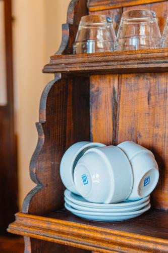 a stack of plates and glasses on a shelf at Agriturismo Montevecchio Isolani in Monte San Pietro