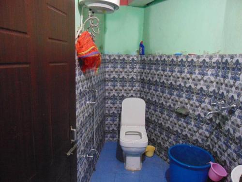 a bathroom with a toilet and a tiled wall at BOJO house in Gangtok