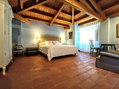 1 dormitorio con 1 cama en una habitación con techos de madera en Los Apartamentos del Palacio en Casalarreina