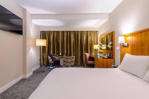 タラにあるGlashaus Hotelのベッドとデスクが備わるホテルルームです。