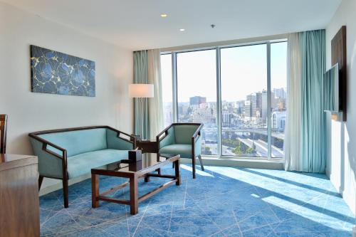 a living room with a couch and a chair and a table at Coral Tower Hotel by Hansa in Amman