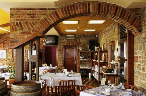 a restaurant with tables and chairs and a brick wall at Hotel Villa De Nava in Nava