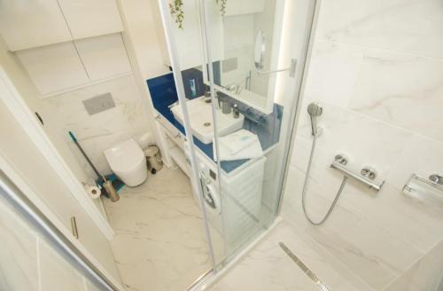 bagno con doccia, lavandino e servizi igienici di Superior Apartments Orbi City Sea View a Batumi