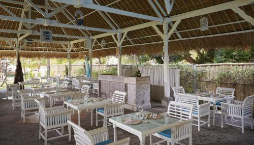 a restaurant with white tables and chairs under a pavilion at SOL by Meliá Benoa Bali All inclusive in Nusa Dua