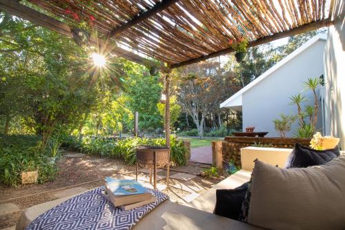 an outdoor patio with a pergola and a table at Hoogwater Farmhouse in Wolseley