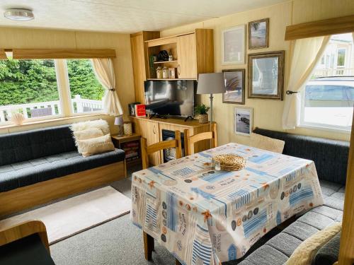 a living room with a table and a couch at Shell Beach Holiday Home Mersea Coopers Beach in East Mersea