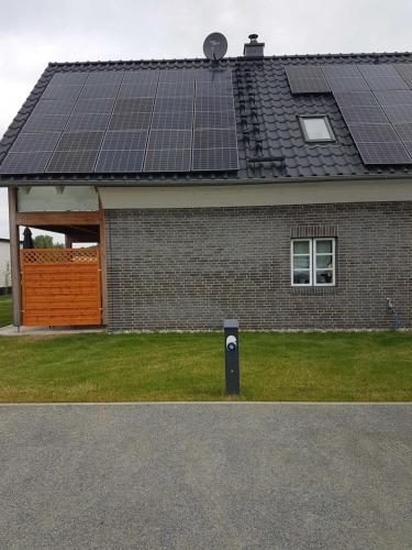 una casa con paneles solares en el techo en komfortables Ferienhaus Allee, en Krummin