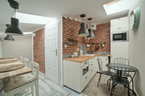 a kitchen and dining room with a brick wall at Urban Nest Apartments Bon 5 in Krakow