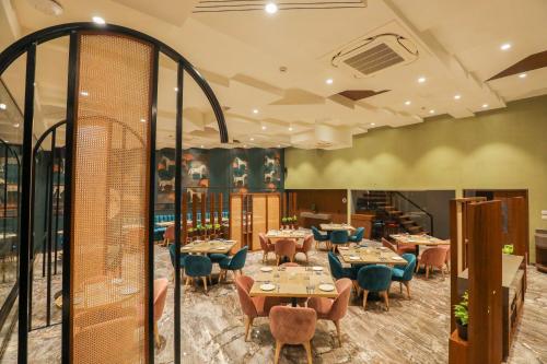 a dining room with tables and blue chairs at Spree Hotel Aurangabad in Aurangabad