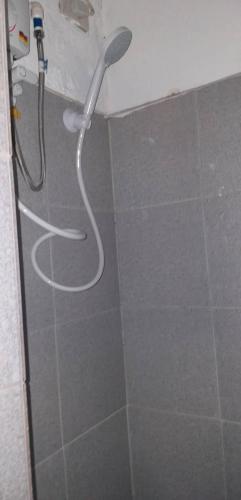a shower with a white hose in a bathroom at De Hagan Transient Baguio City in Baguio