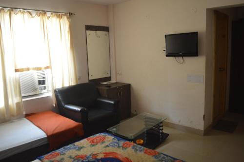 a small living room with a couch and a chair at Hotel City Palace in Brahmapur