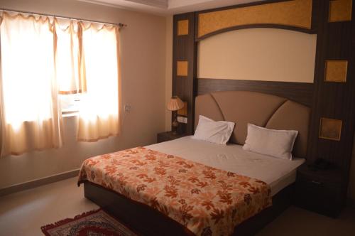 a bedroom with a large bed and a window at Hotel City Palace in Brahmapur