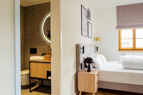 a bedroom with a bed and a bathroom at Bob W Peterhof in Freising