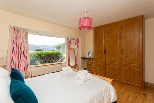 a bedroom with a large white bed with towels on it at Church Island View Holiday Home in Waterville