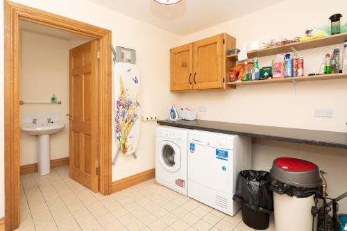 een keuken met een wasmachine en een wastafel bij Church Island View Holiday Home in Waterville