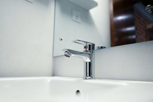 a bathroom sink with a faucet and a mirror at Karuna Hotel Patan Kathmandu in Pātan