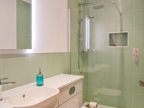 a bathroom with a sink and a glass shower at Fifie Cottage in Johnshaven