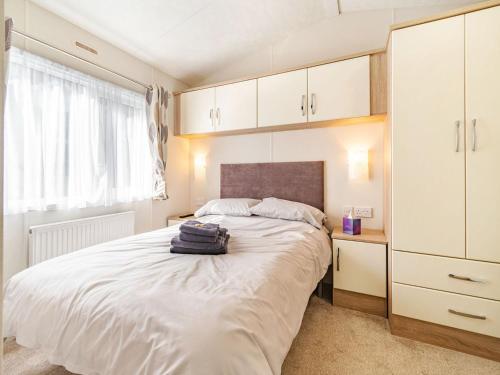 a bedroom with a large bed with white cabinets at Red Wood Lodge - Uk40849 in Scarborough