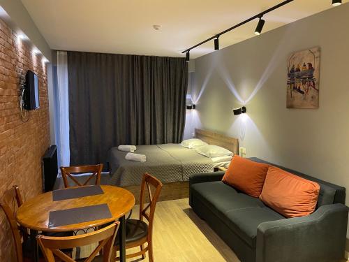 a room with a bed and a couch and a table at SkyWay Twins Studio Gudauri in Gudauri