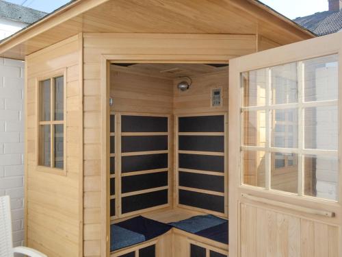 een houten sauna met een glazen deur bij Whitley Bay Hideaway in Whitley Bay
