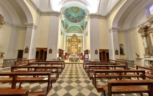 an empty church with wooden benches and a large altar at Monastero Le Grazie in Amelia