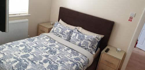 a bed with a blue and white comforter and pillows at London Luxury 3 bedroom 2 bathrooms flat 1 min to Redbridge Station FREE parking & WIFI in Wanstead