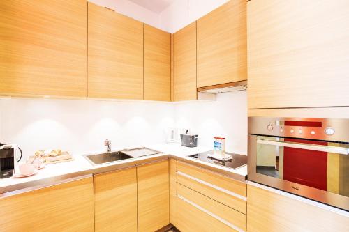 une cuisine avec des armoires en bois et un évier dans l'établissement MASSENA AP4312 By Riviera Holiday Homes, à Nice